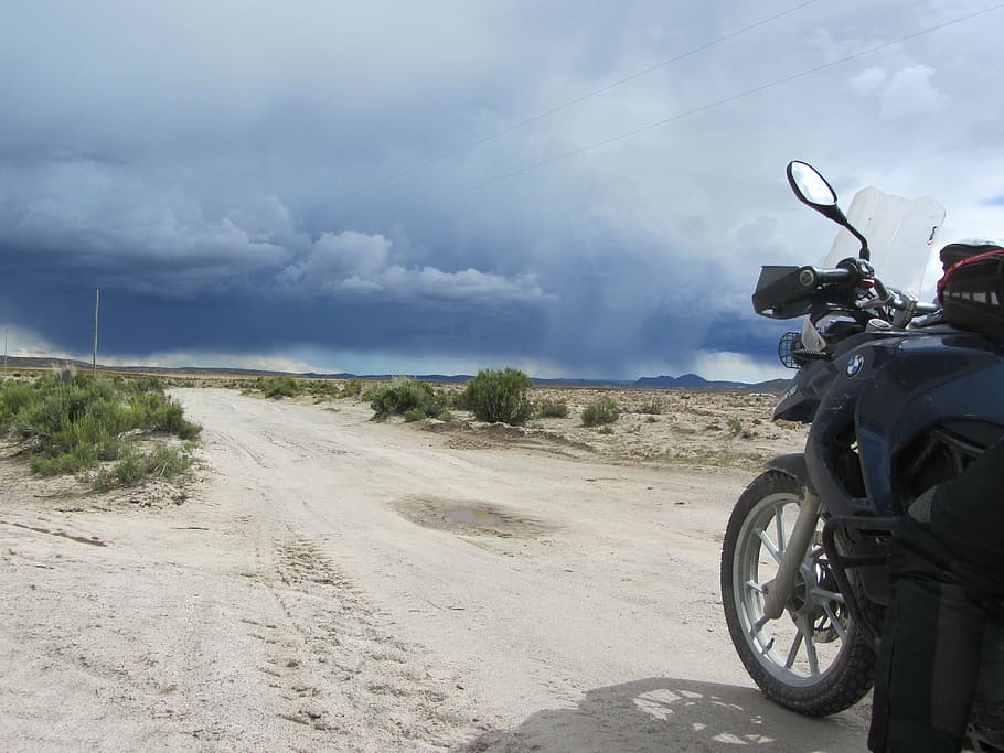 black motorcycle on sand near green plant during daytime, motorcycle tours, HD wallpaper
