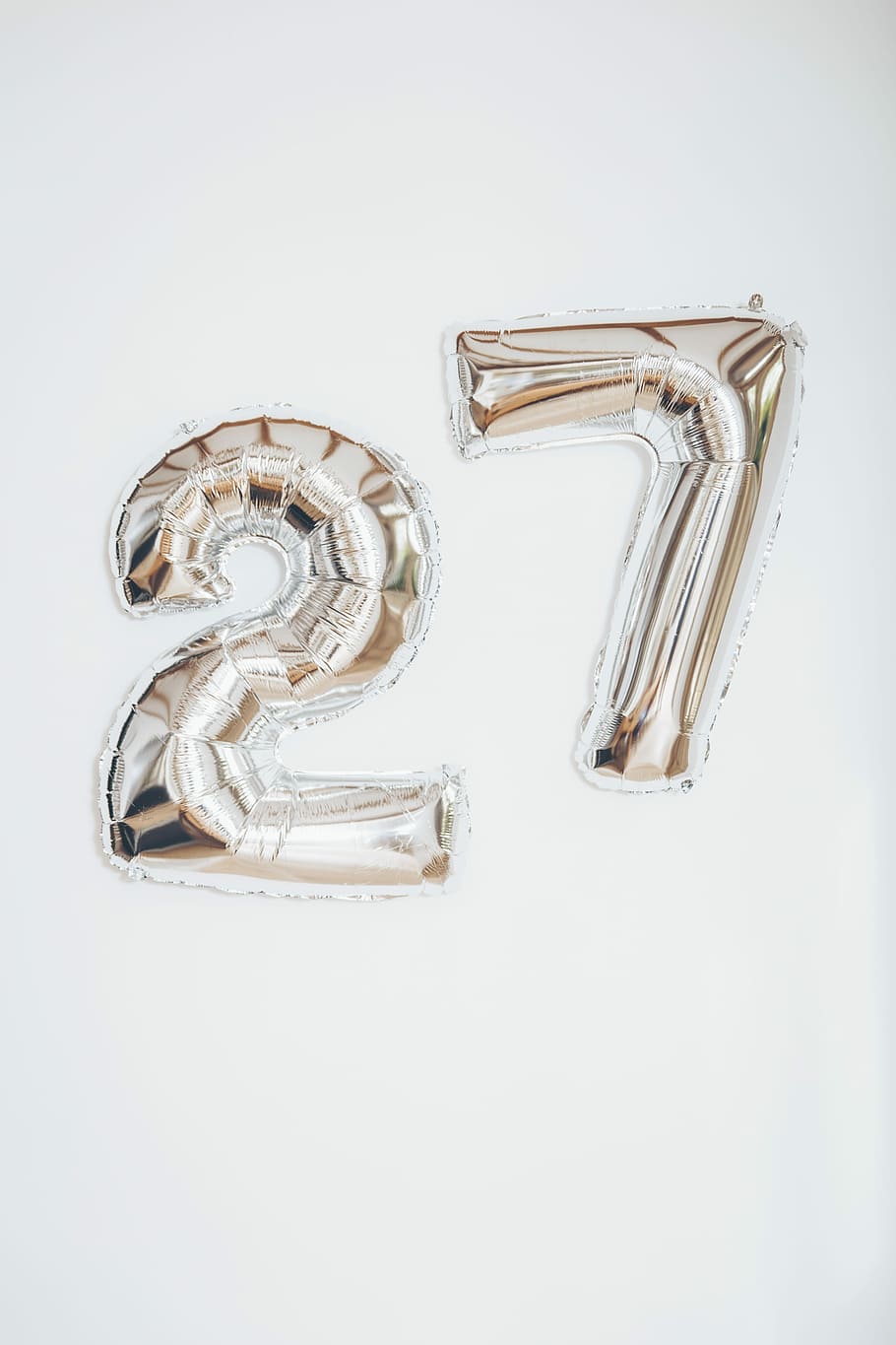 gold 27 balloon, silver 27 inflatable balloon on wall, letters