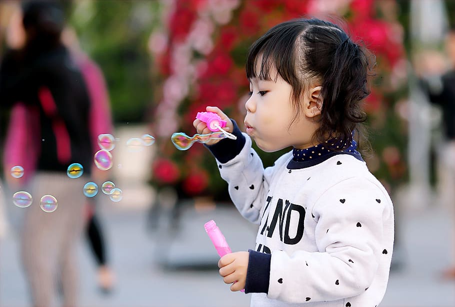 Toddler Girl Wearing White and Black Sweater Holding Plastic Bottle of Bubbles at Daytime HD wallpaper