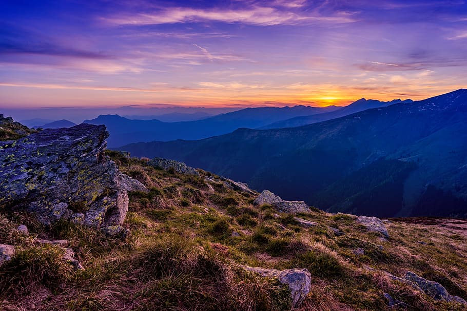 landscape photo of mountains during golden hour, grass field on mountain