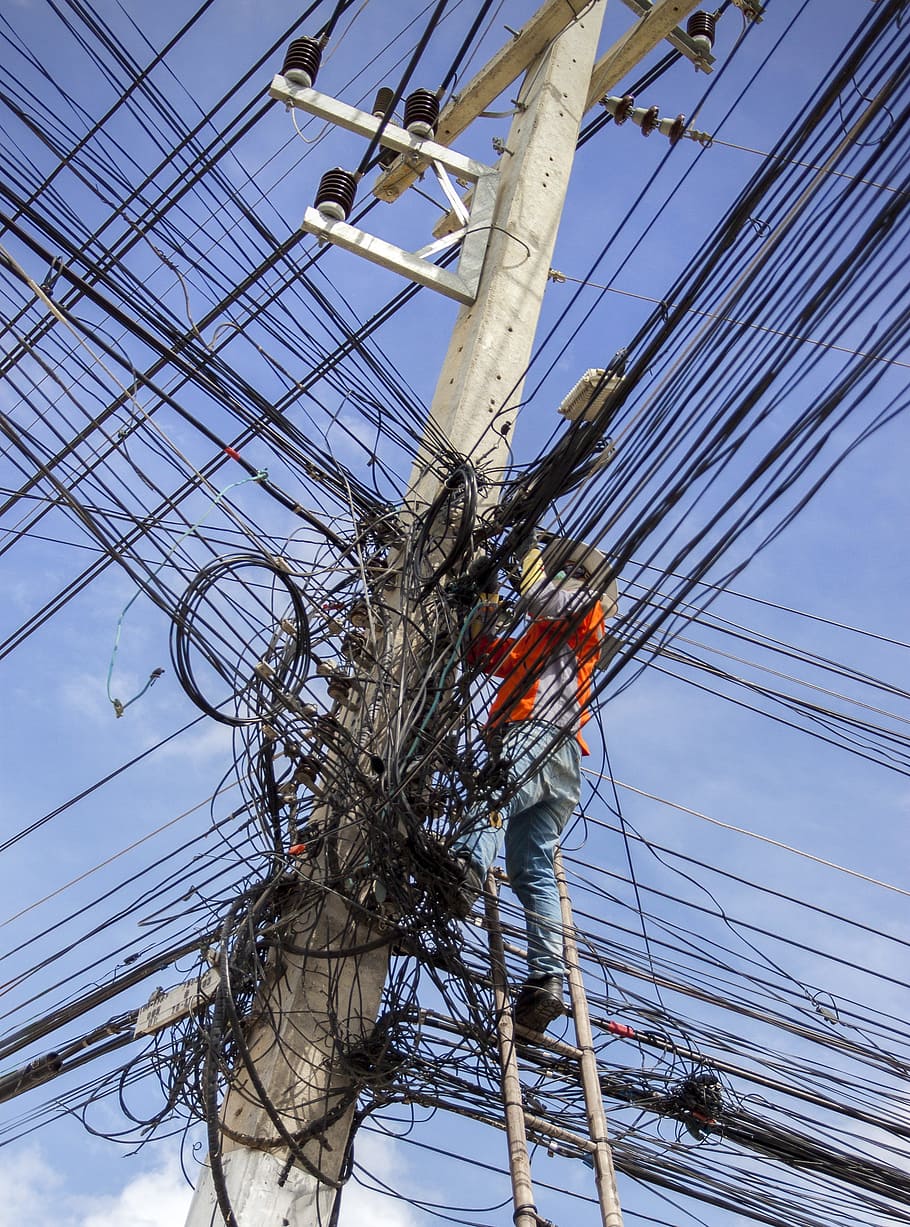 man repairing utility pole, electrical cable mess, energy, electricity