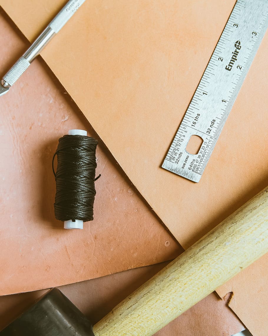 closeup photo of ruler and thread, black thread roll on brown surface HD wallpaper