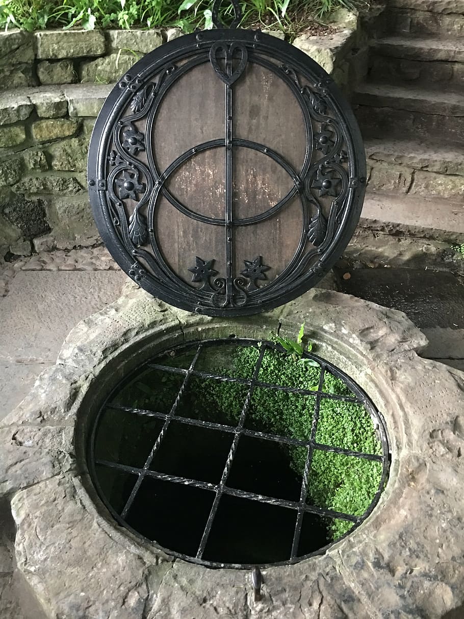 opened round black and gray manhole, glastonbury, red well, spiritual symbol