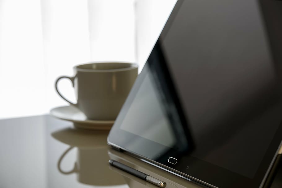 black Samsung Galaxy tablet beside white ceramic cup, modern office, HD wallpaper