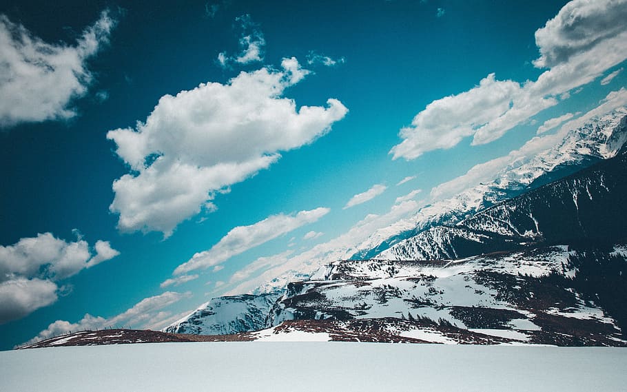 aerial photography of snow filled mountains, cloudy sky above snow covered mountain at daytime HD wallpaper