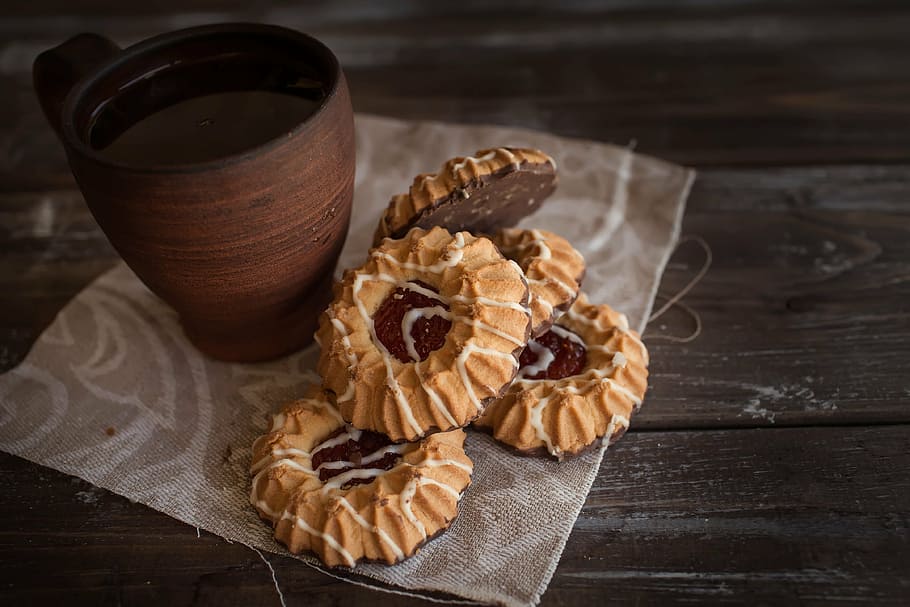 brown ceramic mug beside baked cookies on brown wooden surface HD wallpaper