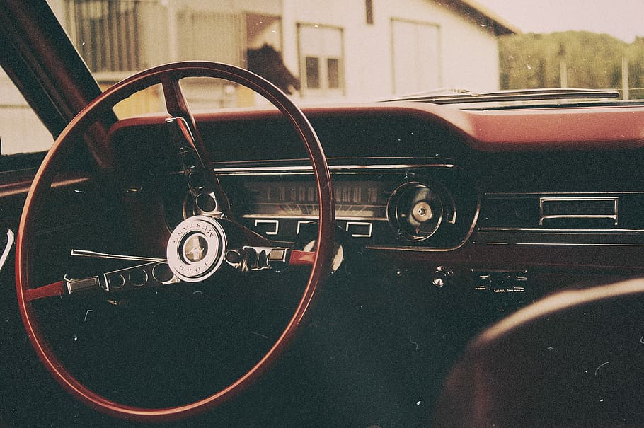 selective focus photo of red and gray car steering wheel, interior photo of black and brown vehicle steering wheel