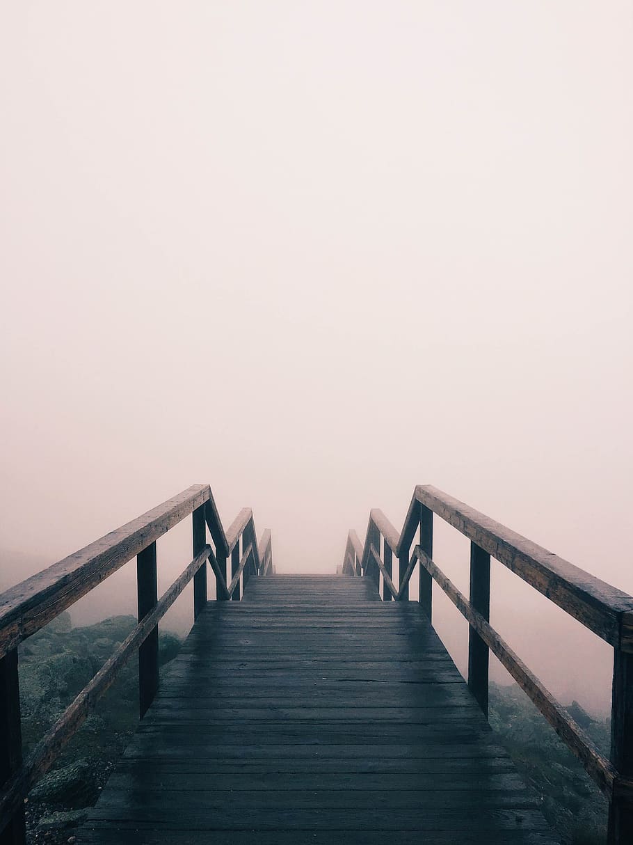 black wooden stairway covered with fog, photo of brow wooden pathway on mountain slope