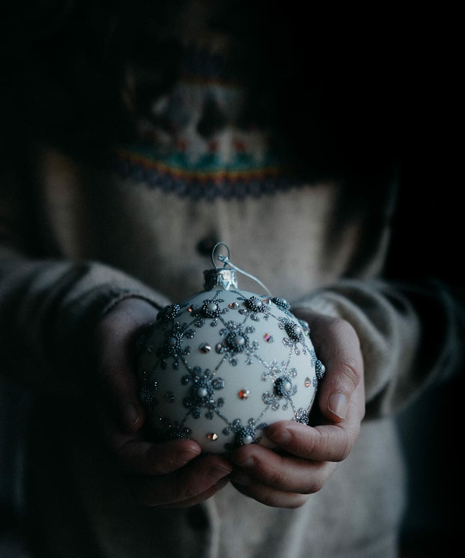 person holding white and grey ornament, round white Christmas bauble on human hands HD wallpaper