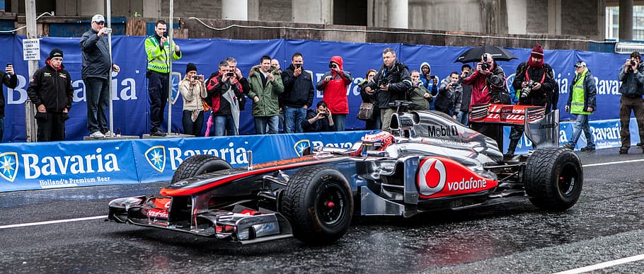 gray and red Vodafone race car on wet road at daytime, formula 1