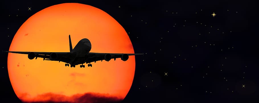 silhouette of airplane flying in the sky during nighttime, sun