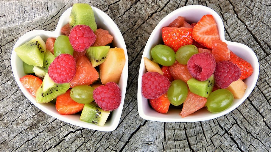 sliced fruits inside white ceramic heart-shaped bowls, fruit salad