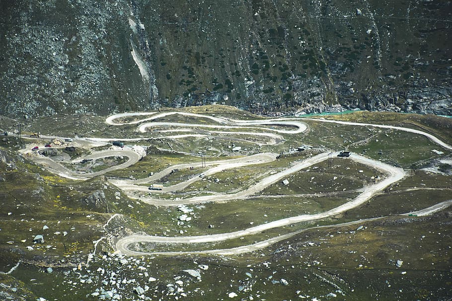pathway with green grass field, aerial view of mountain pass