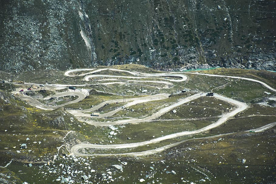 pathway with green grass field, aerial view of mountain pass HD wallpaper