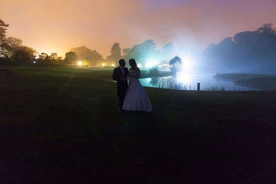 couple walking near body of water during nighttime, wedding, black