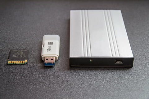 gray power amplifier beside flash drive on gray surface, white HD wallpaper