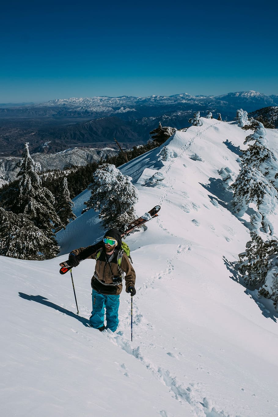 person standing on snow covered mountain, person walking on snow carrying snowskis HD wallpaper