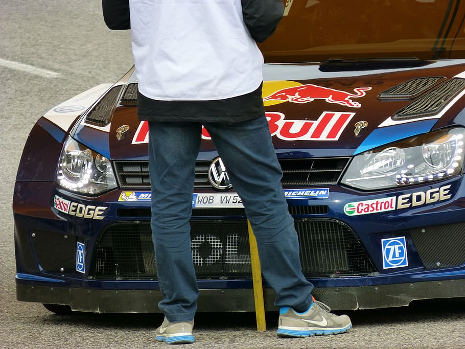 person standing in front of blue Volkswagen RedBull vehicle HD wallpaper