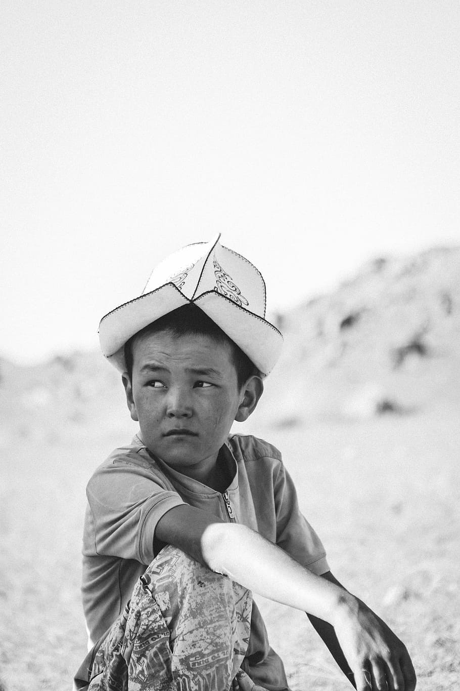 grayscale photography of box with hat, boy in zip-up shirt and white hat HD wallpaper