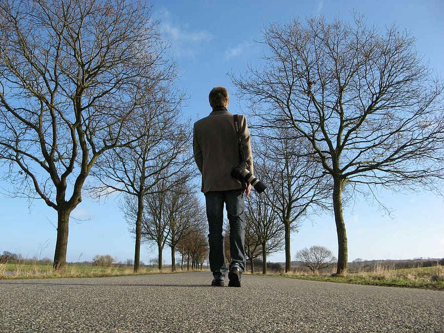 man in brown suit jacket and black jeans walks on gray asphalt road HD wallpaper