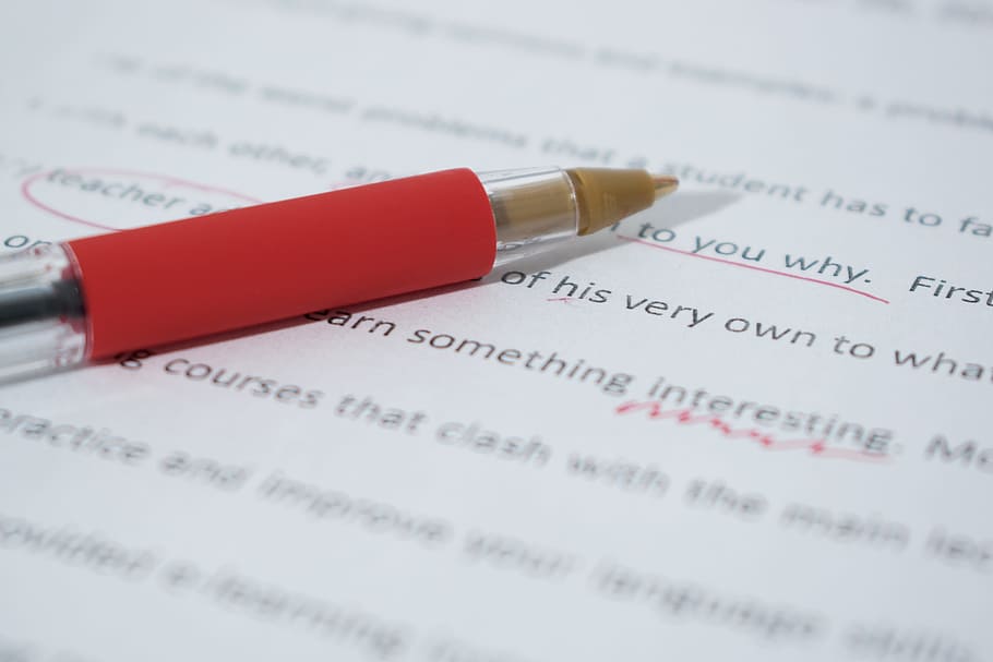 close up photo of red pen, correcting, proof, paper, correction
