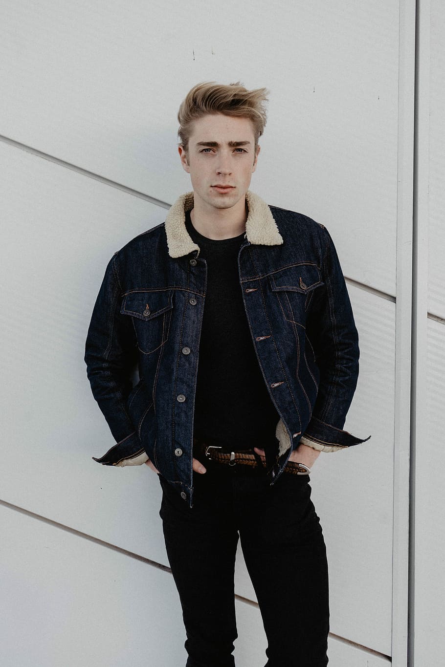 man wearing blue denim jacket and pants, man standing beside wall HD wallpaper