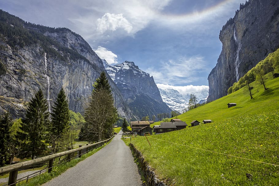 road near green hill during daytime, green grass field beside gray mountain HD wallpaper