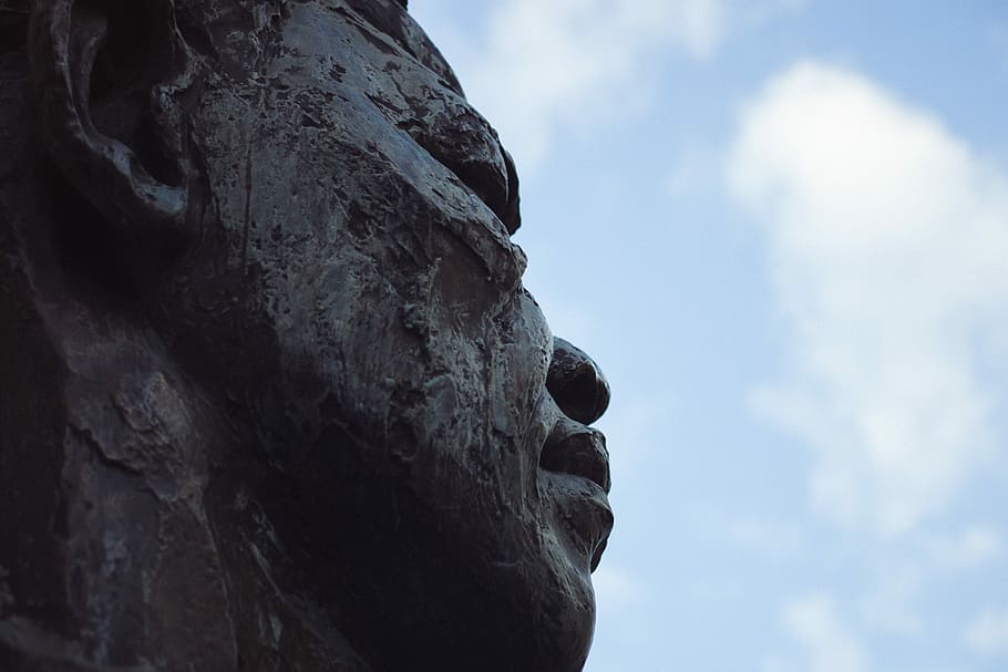 person statue under white clouds closeup photography, closeup photo of man's face statue HD wallpaper