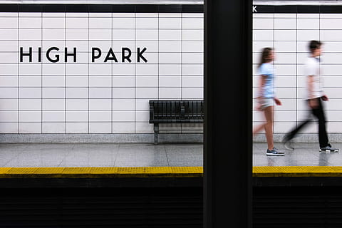 man and woman walking away from High Park signage, two person walking on train rail sidewalk HD wallpaper