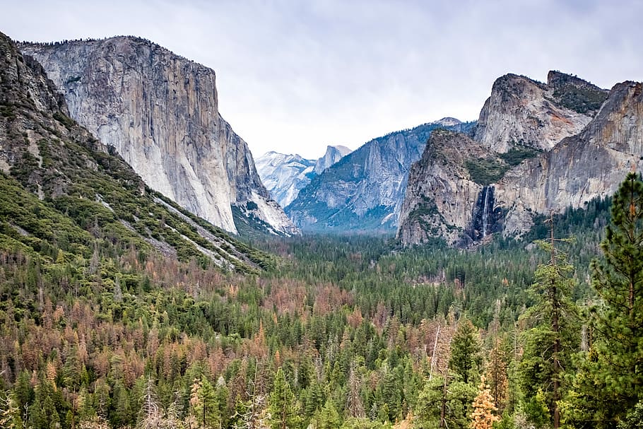 landscape photography of mountain formations and green leafed trees, mountain surrounded by forest HD wallpaper