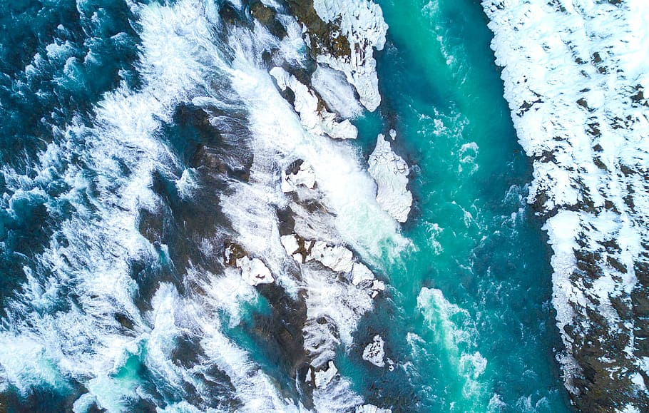 top view photography of green water river beside stones covered with snow at winter, aerial photo of crashing waves on ocean during daytime HD wallpaper