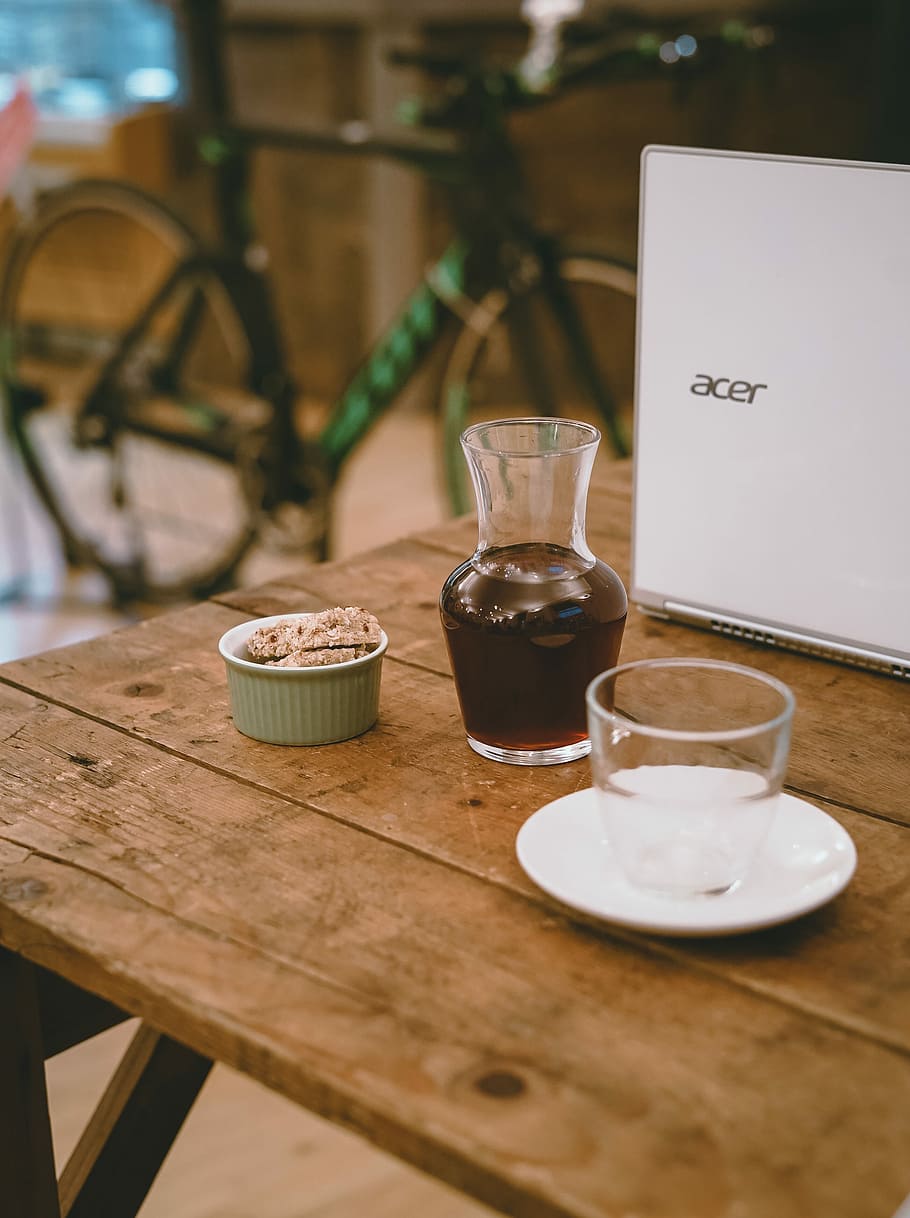 clear glass bottle and shot glass on table, clear glass vase beside laptop on table HD wallpaper