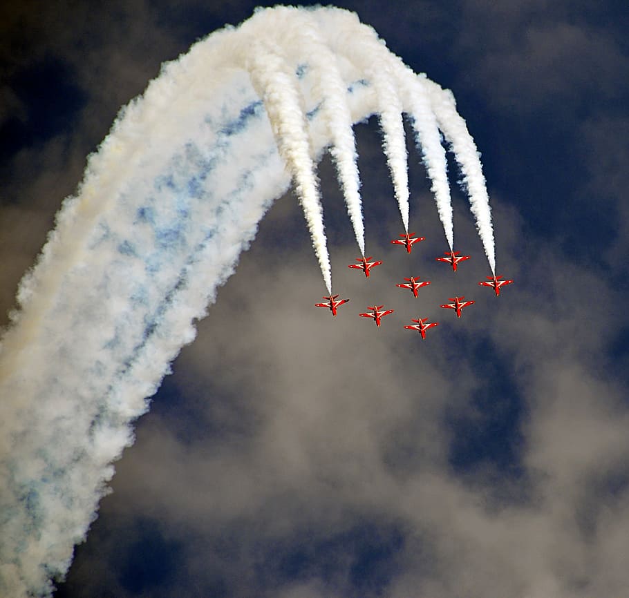 nine red jet plane with doing air shore during daytime, airshow
