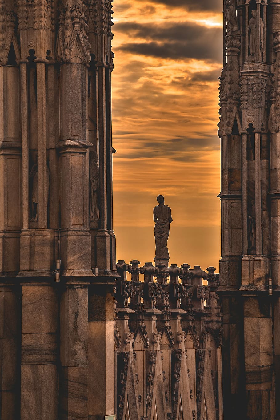 low-light photo of woman statue in the middle of high-rise building, brown ancient buildings HD wallpaper