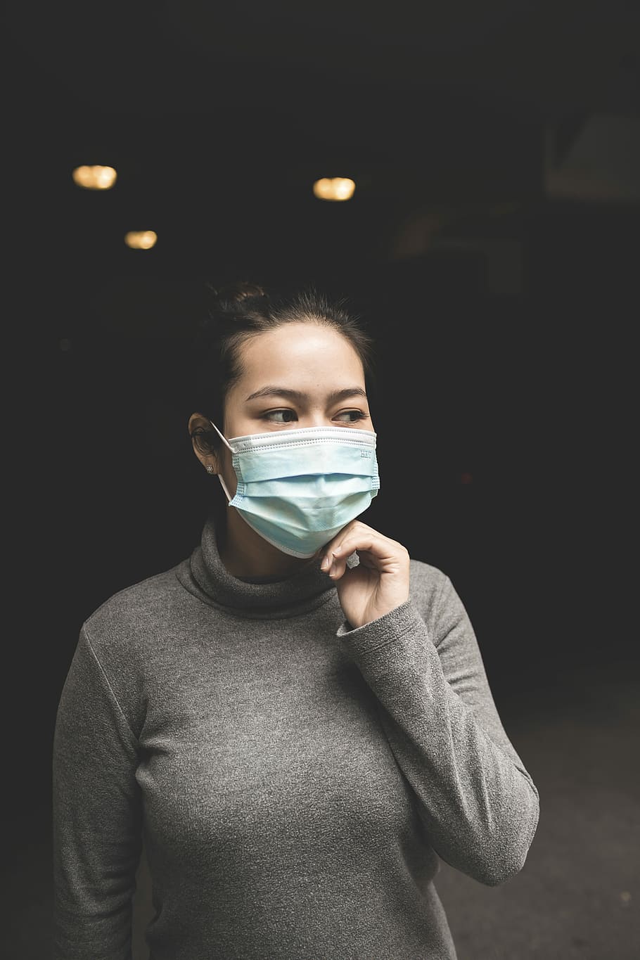 woman wearing teal mask and gray turtle-neck shirt, woman wearing grey turtleneck long-sleeved shirt and blue face mask