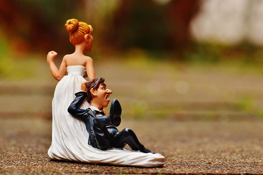 selective focus photography of woman pulling man figurine, grind down the aisle