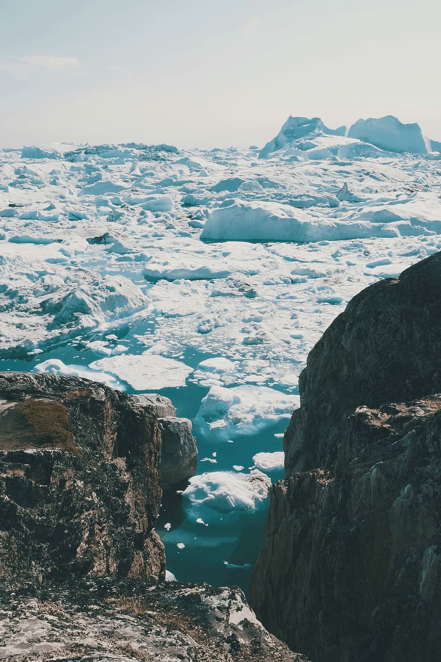 two brown rocks surrounded by ice blocks under white sky during daytime, ice formation on body of water during daytime HD wallpaper