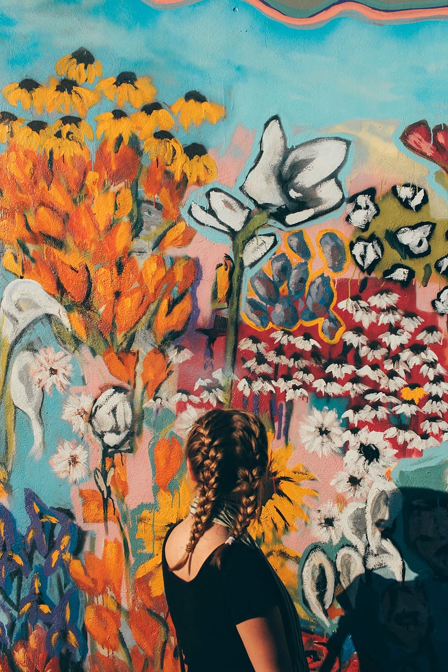 woman in black t-shirt looking at floral wall paintings during daytime HD wallpaper