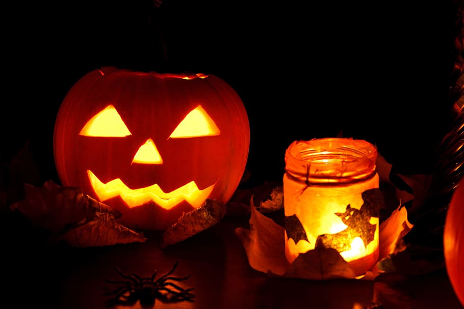 jack o lantern beside glass jar with candle, autumn, black, celebration