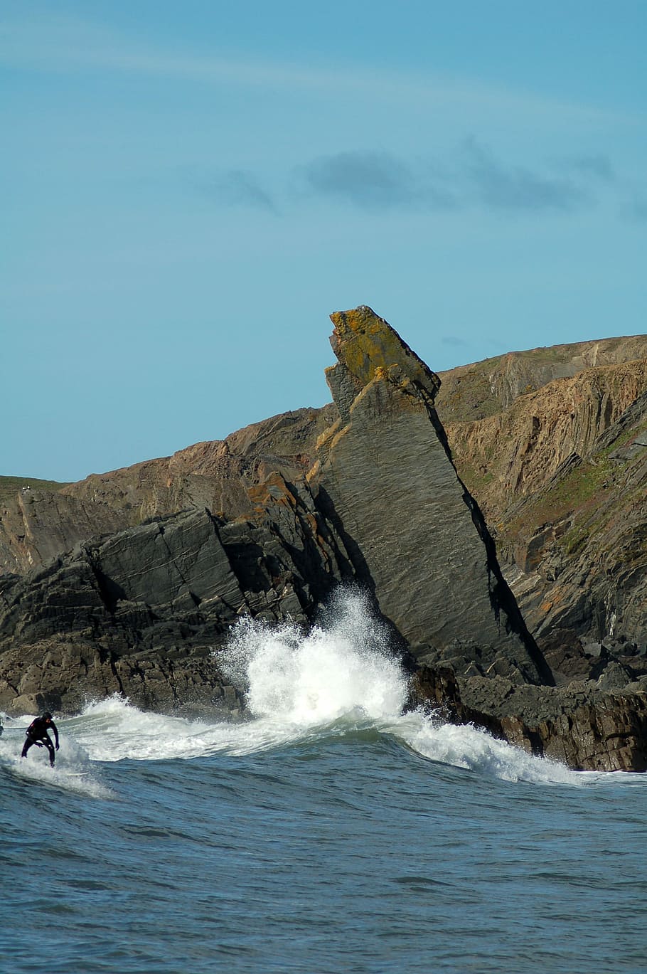 person doing surfboarding near the cliff, man surfing at beach during daytime photo HD wallpaper