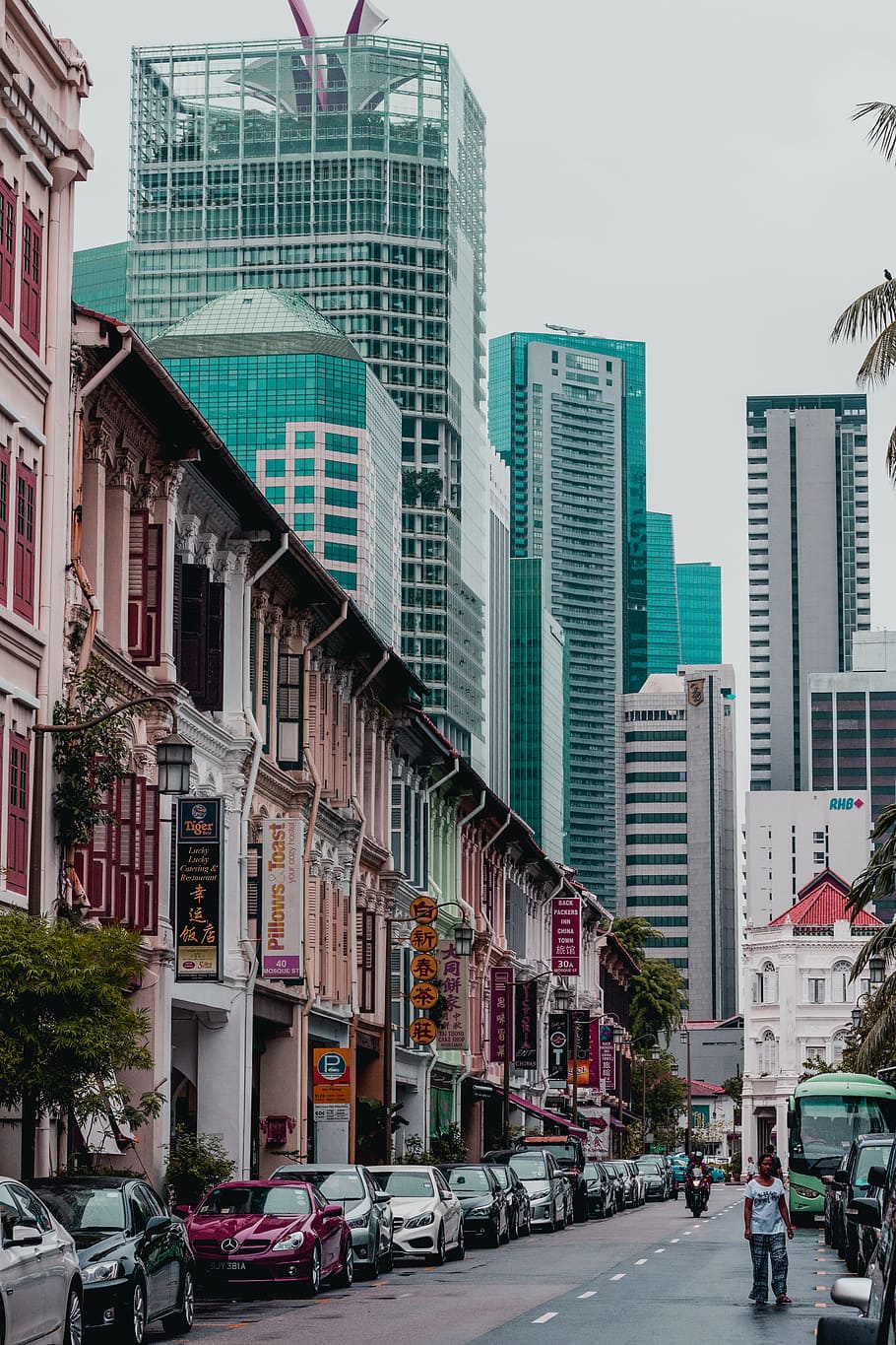 street between high-rise building, cars park near cafe and commercial businesses buildings HD wallpaper