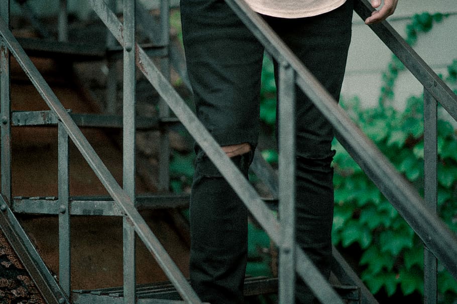 person wearing distressed black jeans standing in stair, person standing on the stair HD wallpaper