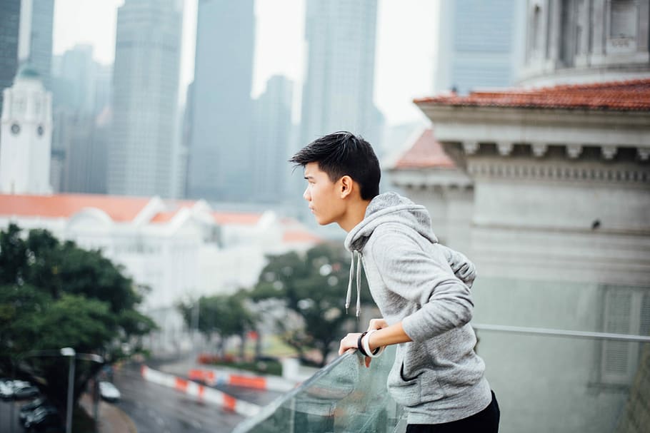 man standing near glass fence, selective focus photo of man standing on balcony HD wallpaper