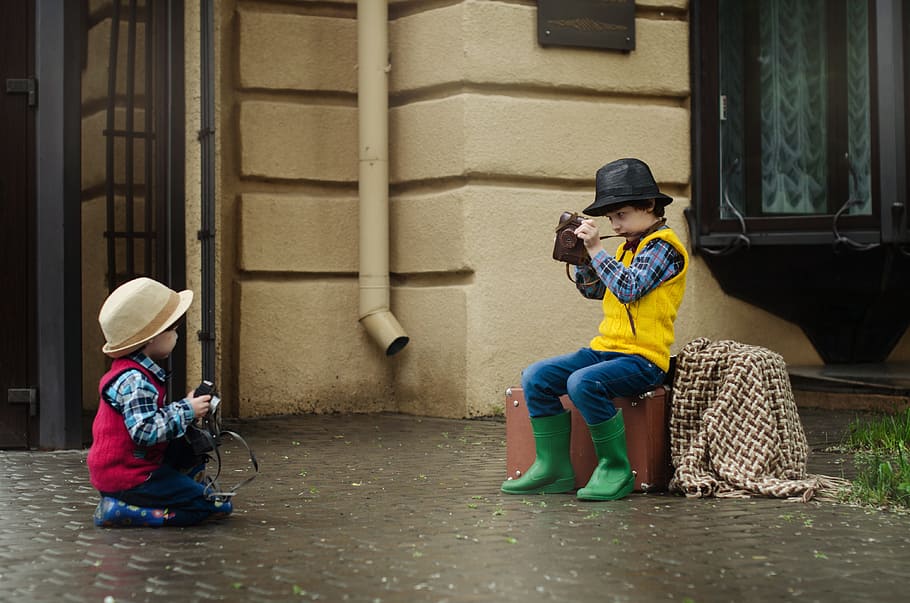 boy sitting on case taking photo of child on floor, camera HD wallpaper