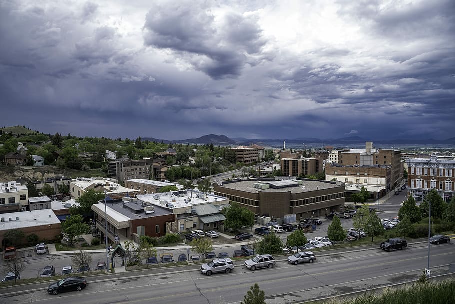 Town of Helena under heavy clouds with mountains in the background HD wallpaper