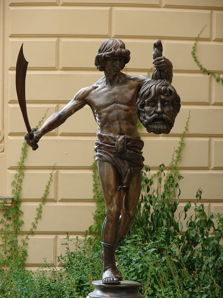 man's profile holding sword and head statuette, david, goliath