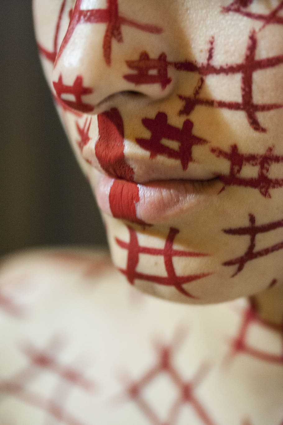 close-up and selective focus photography of person's face with red number sign markings HD wallpaper