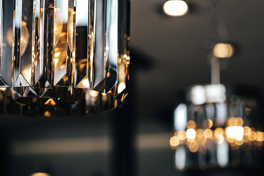 Elegant black designer chandelier with a lit lightbulb, rich