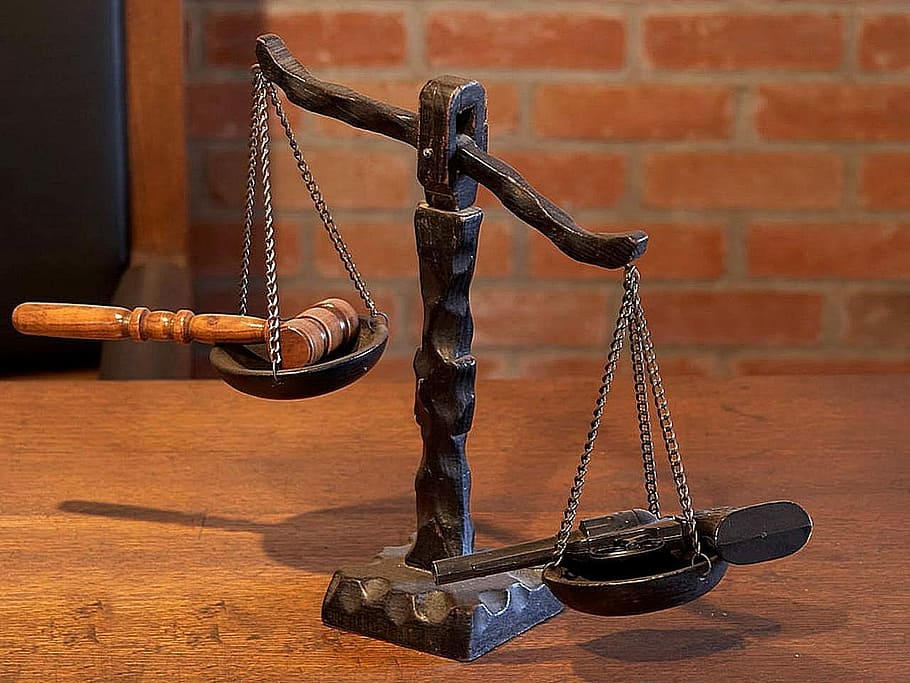 black balance scale with gavel and pistol, weighing scale, justice