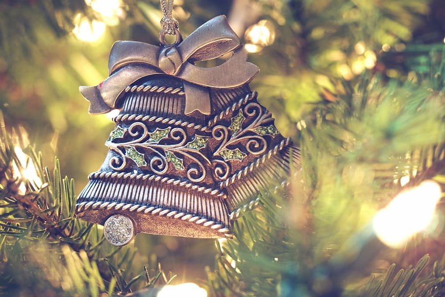 brown bell hanging on christmas tree, gold-colored bell decor